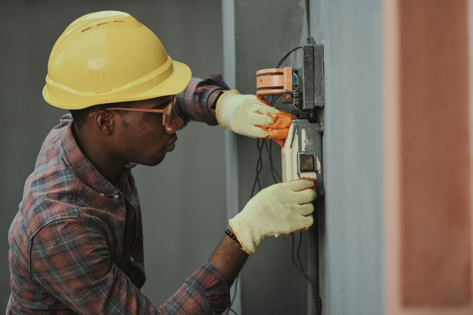 Tradesperson fitting a wall fixture with careful attention to detail